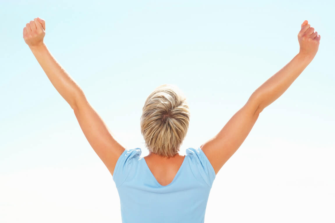 Woman raising her arms with confidence after learning about updated FDA hormone therapy safety information